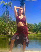 Load image into Gallery viewer, A woman wears a soft cotton lycra two tone skirt that is red and grey with mandala print. The skirt is adjustable in length with cinch options on 4 sides. She is standing in front of palm trees on a beach in Hawaii.
